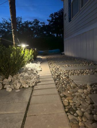 A walkway with lights and rocks in the middle of it.